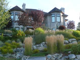 Natural boulder retaining wall and grass walkway