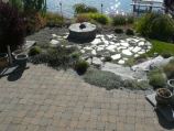Red paver patio overlooking fire pit and lake