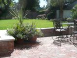 Red brick walls with cement cap and red paver patio
