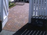 Red clay paver patio with white picket fence