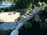 Rock circle firepit with stone curved retaining wall