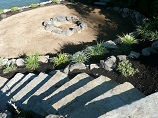 Stone stairway down to rock ringed firepit