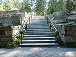 Concrete stairway splitting multiple tier retaining walls with drainage