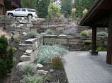 Three tier rock retaining wall overlooking paver patio