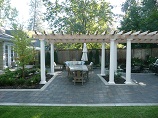 Flower beds in paver patio with custom pergola
