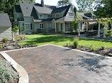 Paver parking overlooking lawn and flower beds