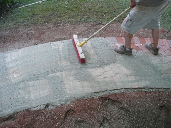 Sweeping polymeric joint-filler into the pavers.