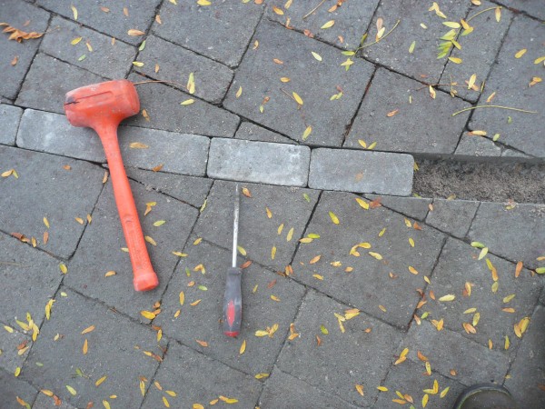 Installing sand and then pavers into the cut