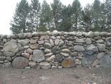 Stone flower design built into drystacked basalt retaining wall