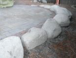 Medium-sized granite boulders framing a paver patio