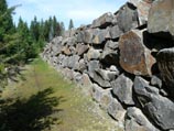 Six foot high stacked, basalt boulder wall
