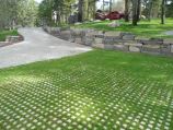 Paver driveway with grass grid pavers and boulder wall constructed of ledge stone supplied by Stutzke Stone of Clark Fork