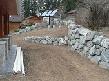 Natural rock retaining wall split into two tiers