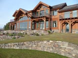 Sunset bathed windows with lawn and drystacked rock landscaping