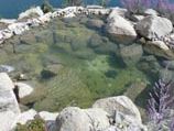 Collection pond with boulder borders and view of the lake