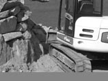 The Special Additions bobcat placing heavy boulders in a retaining wall