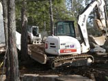 Special Additions Landscaping, LLC excavation equipment preparing to construct a rock retaining wall